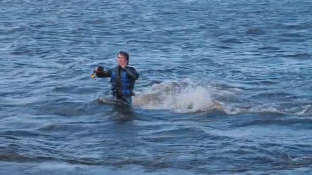 Ein Mann bewegt sich im Fluss mit einem an seinen Füßen befestigten Schwungbrett — Stockvideo
