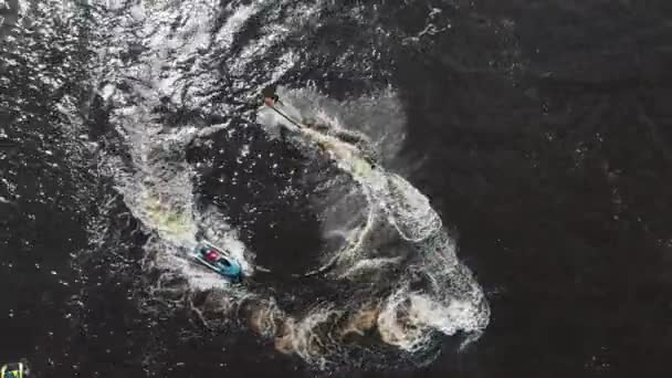 Um homem voando sobre a água e outro homem montando jet ski - vista aérea — Vídeo de Stock