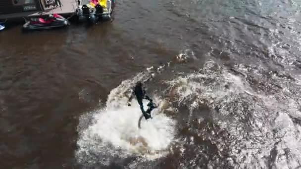 Ein Mann fliegt in der Nähe des Hausbootes über das Wasser - Luftaufnahme — Stockvideo
