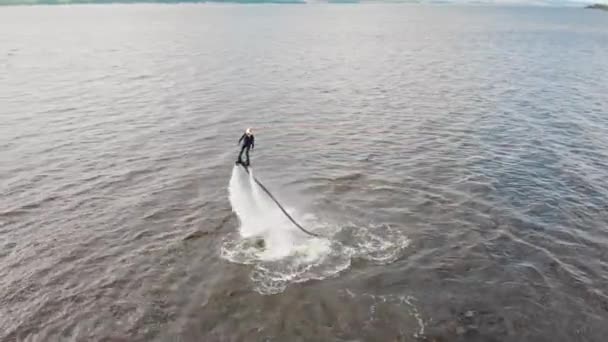 Deportes acuáticos - un hombre entrenando volando sobre el agua en el flyboard cerca de una isla - vista aérea — Vídeos de Stock