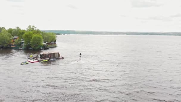 島の近くのフライボード上の水の上を飛ぶ男の訓練-空撮 — ストック動画