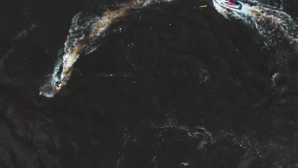 Sport acquatici - un uomo che vola sopra l'acqua sul flyboard in cerchio con un jet ski al guinzaglio - vista aerea — Video Stock