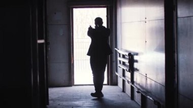 Tehlikeli bir adam silueti ortaya çıkıyor ve iki silah ateşliyor.