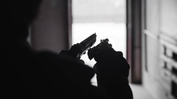양손에 총 두 자루를 들고 있는 사람의 실루엣 — 비디오