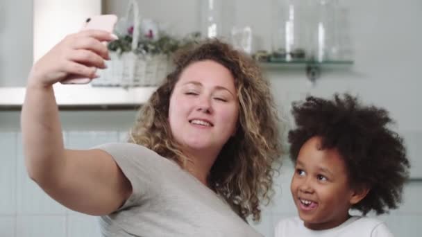 Madre blanca y su hija negra mixta tomando una selfie en el teléfono — Vídeos de Stock