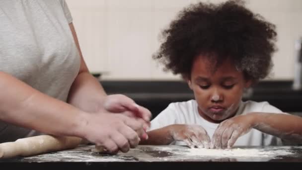 Menina preta com sua mãe fazendo massa - a menina brincando com a farinha — Vídeo de Stock