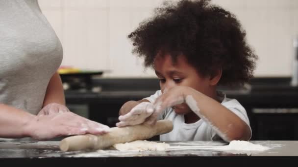 Menina negra com sua mãe fazendo massa na cozinha brilhante — Vídeo de Stock