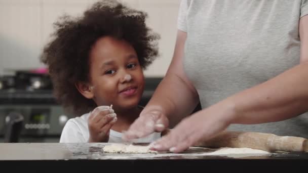 Nero poco sorridente ragazza degustazione un pezzo di pasta cruda — Video Stock