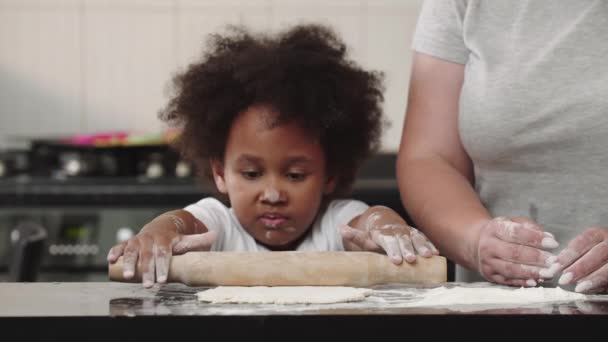 Fetiță neagră care laminează aluatul în bucătăria strălucitoare — Videoclip de stoc