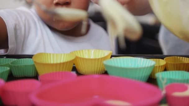Niña negra pone la masa en el molde de la torta pequeña en forma de corazón — Vídeos de Stock