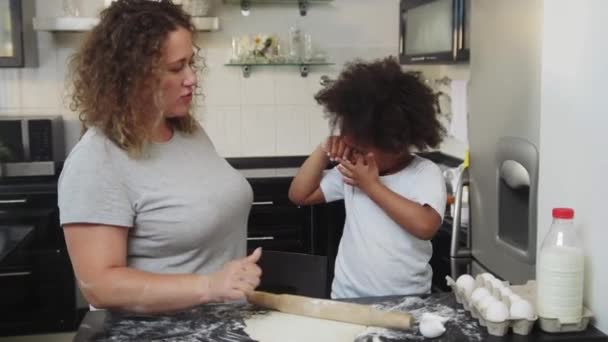 Familie bagning - sort lille pige og hendes mor gør cupcakes i køkkenet - giver en high five – Stock-video