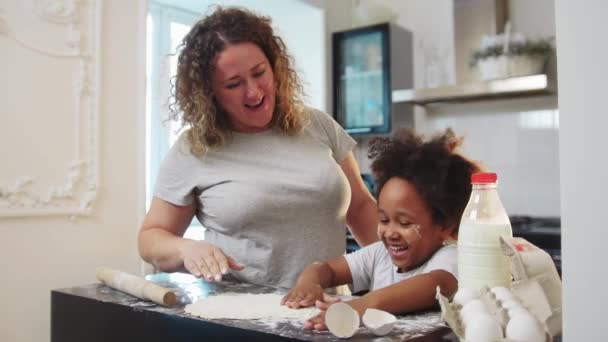 Cuisson familiale mixte - petite fille noire et sa mère jouant avec la nourriture — Video