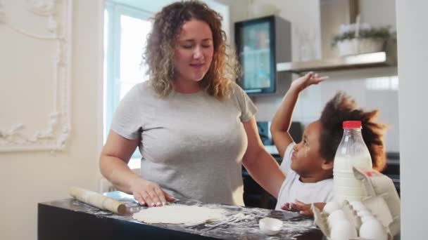 Cuisson familiale mixte - petite fille noire et sa mère jouant avec la nourriture et la farine — Video