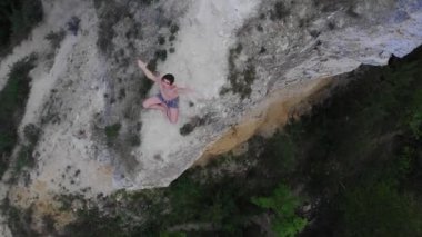 Sabahın erken saatlerinde uçurumda meditasyon yapan genç bir adam avuçlarını birbirine bağlıyor.