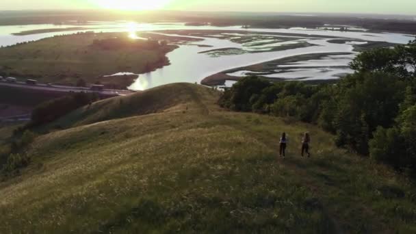 Дві молоді жінки бігають вниз до заходу сонця — стокове відео