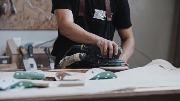 Uomo operaio macinazione di una tavola di legno in officina con uno strumento — Video Stock