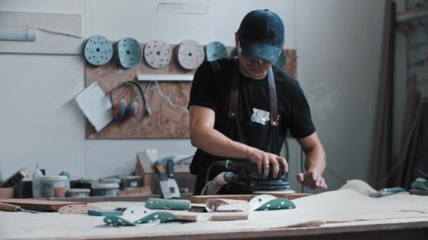 Bir enstrüman kullanarak tahta parçaları öğüten bir işçi. — Stok video