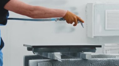 Detayları sprey boyayla kaplayan işçi.