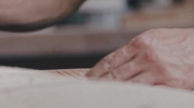 İşçi, ahşap bir detayı öğütme makinesiyle daha yumuşak yapar.