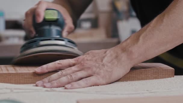 El trabajador moliendo los ángulos de un detalle de madera — Vídeos de Stock