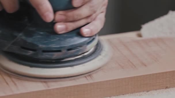 Столярний - працівник шліфує плоску поверхню дерев'яної деталі на столі — стокове відео