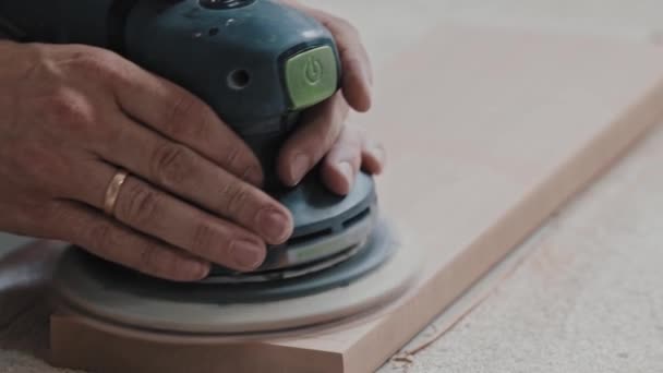 Trabajos de carpintería - trabajador hace que la superficie superior de un detalle de madera más suave con una máquina de pulir — Vídeos de Stock