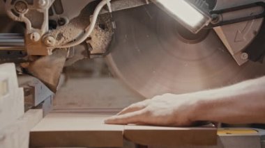 Marangozluk işi. İşçi yavaşça ahşap bir testereyle odun parçalarını kesiyor.