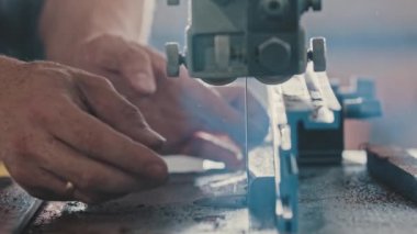 Marangozluk çalışıyor. İşçiler küçük tahta parçaları otomatik testereyle kesiyor.
