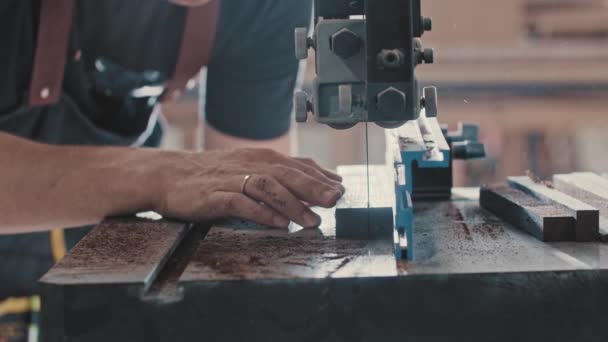 Trabajos de carpintería - el trabajador corta lentamente el detalle de madera con una sierra automática — Vídeos de Stock