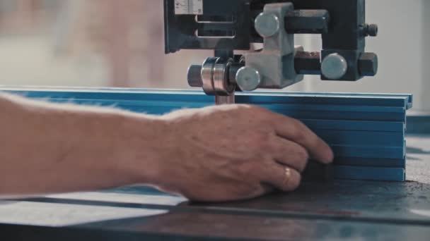 Trabajos de carpintería - el trabajador corta lentamente la pequeña pieza de un detalle de madera con una sierra automática — Vídeos de Stock