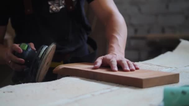 Timmerwerk in werkplaats - arbeider die de hoeken van een houten detail slijpt — Stockvideo