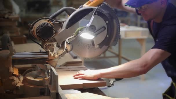 大工ワークショップ-大きな円形ののこぎりを使用して木製の机の上にノッチを切断男労働者 — ストック動画