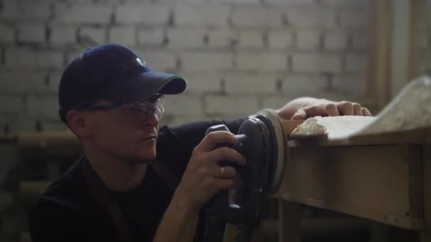 Snickeri verkstad - man arbetare slipning sidan av en träplanka — Stockvideo