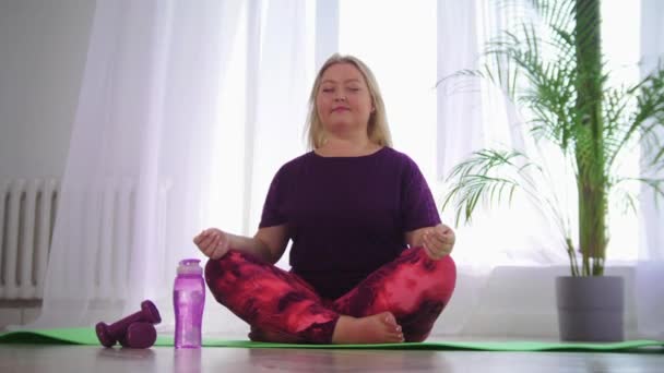 Pelatihan kebugaran wanita pirang yang kelebihan berat badan minum air dari botol — Stok Video