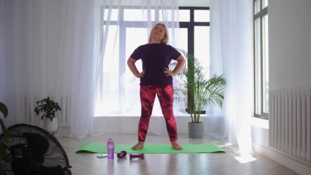 Фитнес-тренировка - блондинка с избыточным весом, занимающаяся фитнес-упражнениями - разогревает шею — стоковое видео
