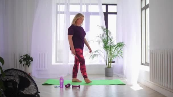 Fitness träning - blond överviktig kvinna gör fitness övningar - värma upp sin kropp med böjning åt sidorna — Stockvideo