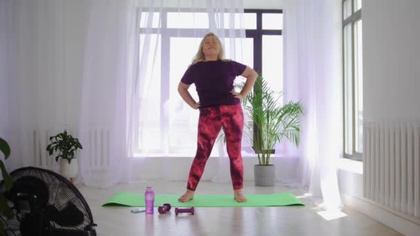 Entrenamiento de fitness - mujer rubia con sobrepeso haciendo ejercicios de fitness - calentando su cuerpo con movimientos de círculo — Vídeos de Stock