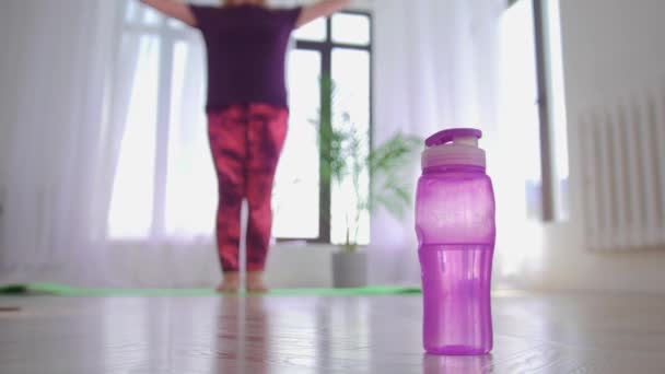 Fitness-training - vrouw met overgewicht traint met kleine halters en legt ze neer - neemt een fles water van de vloer — Stockvideo