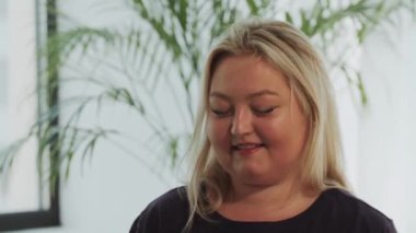 Sarışın şişman kadın fitness eğitiminden sonra şişeden su içiyor.