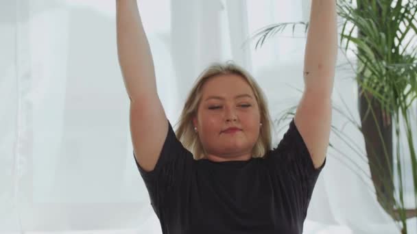 Bionda sorridente donna in sovrappeso che fa esercizi di fitness per le mani utilizzando manubri — Video Stock