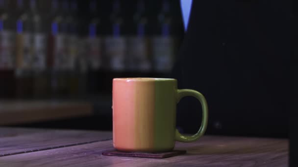 Throwing a sugar cube in a cup of coffee - coffee splashes on the table — Stock Video