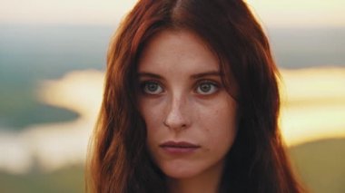 Çilli, kızıl saçlı ve burnu delinmiş güzel bir kadın.