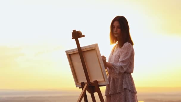 外の絵画-若い美しい女性が日没時に絵を描く — ストック動画