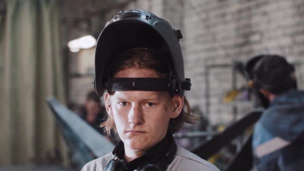 Ung ingefära man som arbetar på anläggningen - sätter ner skyddshjälmen — Stockvideo