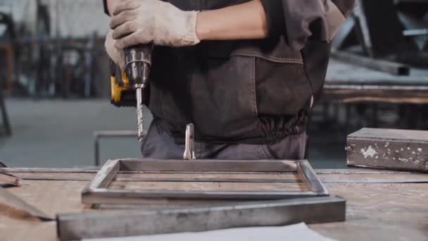 Молодой человек, работающий на заводе - бурение скважин в металлоконструкции — стоковое видео