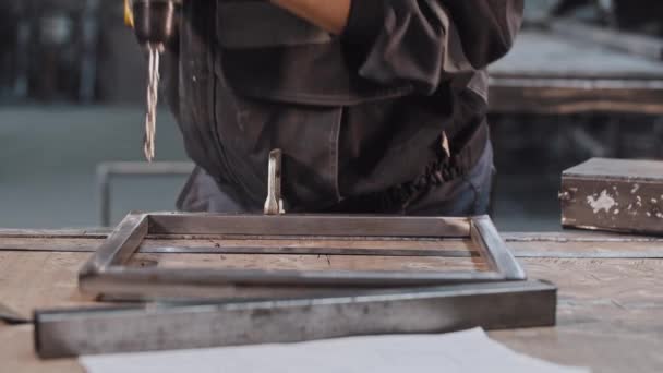 Jeune homme travaillant à l'usine de construction - perçage de trous dans la construction métallique — Video