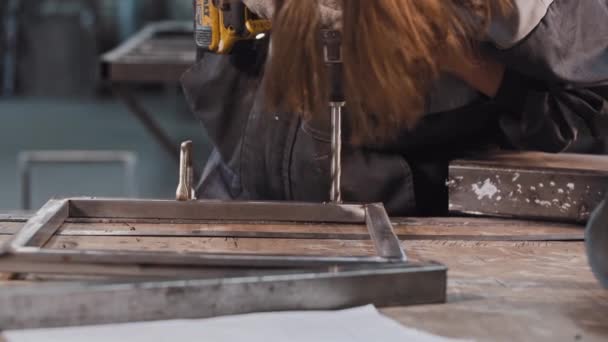 Junger Mann im Produktionsbetrieb - Löcher in Metallbau bohren — Stockvideo