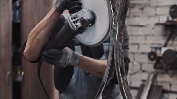 Egy férfi, aki körkörös fémdarabot őröl egy nagy körfűrésszel. — Stock videók