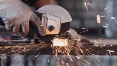 Üretim tesisi - insan işçisi metal parçalarını testereyle kesiyor - parlak parıltılar