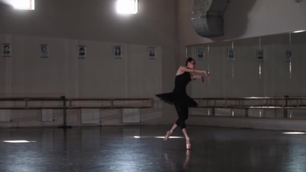 晚上，穿着黑色燕尾服的职业女芭蕾舞演员在一个空旷的镜像演播室里跳舞 — 图库视频影像